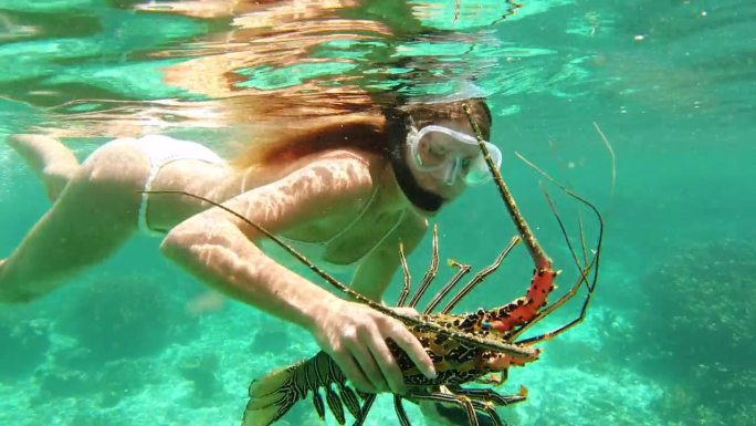 鱼叉钓鱼，浮潜和龙虾与妇女在海里游泳，旅行和冒险。热带，狩猎和潜水与年轻人和鱼叉在海洋为暑假，鱼和假