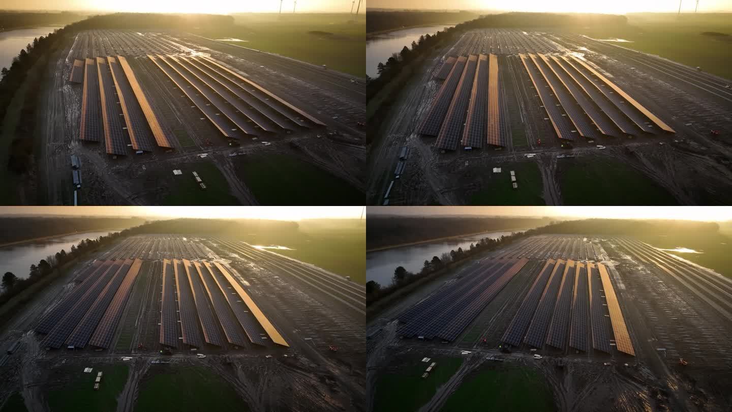 光伏公园的施工现场，有太阳能电池板、太阳能组件、施工车辆和工人的太阳能架。从左至右为地面安装太阳能光