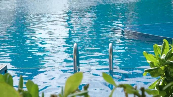 热带度假胜地游泳池铬钢扶手下降到乌龟清澈的室外游泳池水的特写