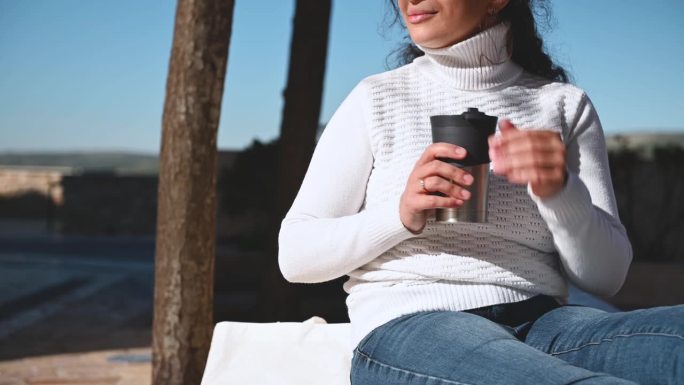 一个漂亮女人在户外用不锈钢保温杯喝咖啡的剪辑视频