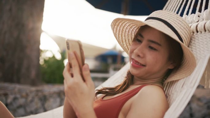 穿泳衣的女人在沙滩上看手机