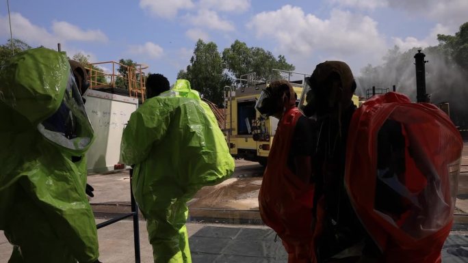 安全救援小组在开始工作前与危险品防护服开会，就化学品泄漏进行头脑风暴