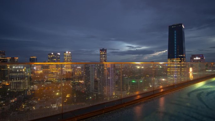 傍晚时分照明雅加达市中心屋顶游泳池全景4k延时印度尼西亚