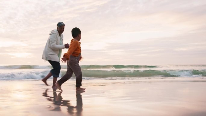海滩上，快乐的奶奶带着孩子在水里奔跑，在海边兴奋地为假期或户外度假而一起度过。冒险，旅行和奶奶在海边