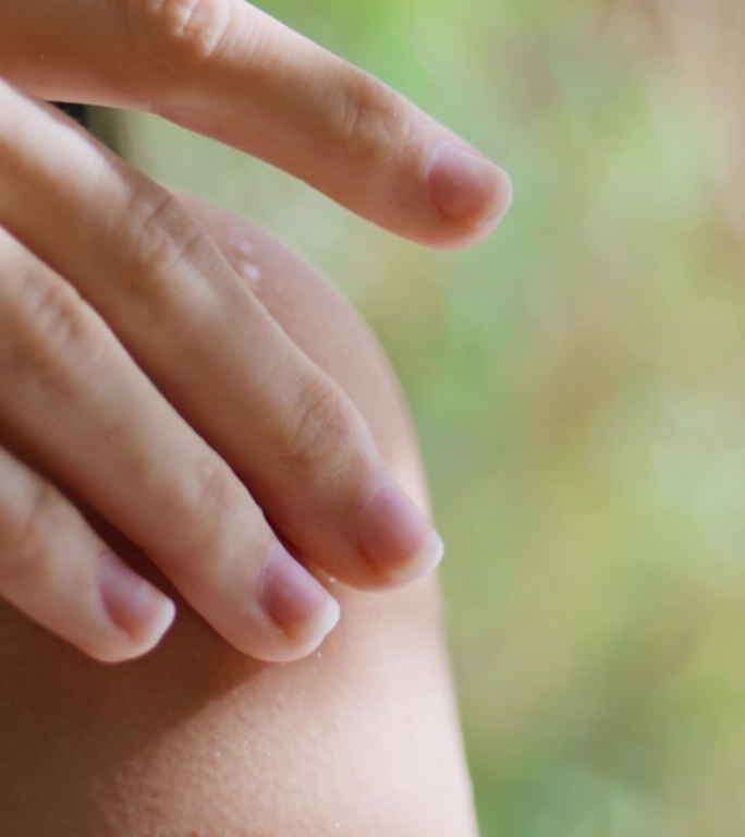 女人的手触摸皮肤热带度假胜地垂直特写。手指模型手臂