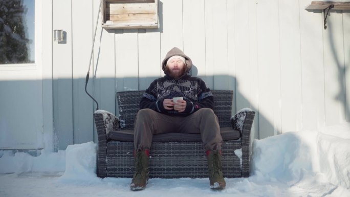 一个男人坐在沙发上，品味着冬天的热饮——静态镜头