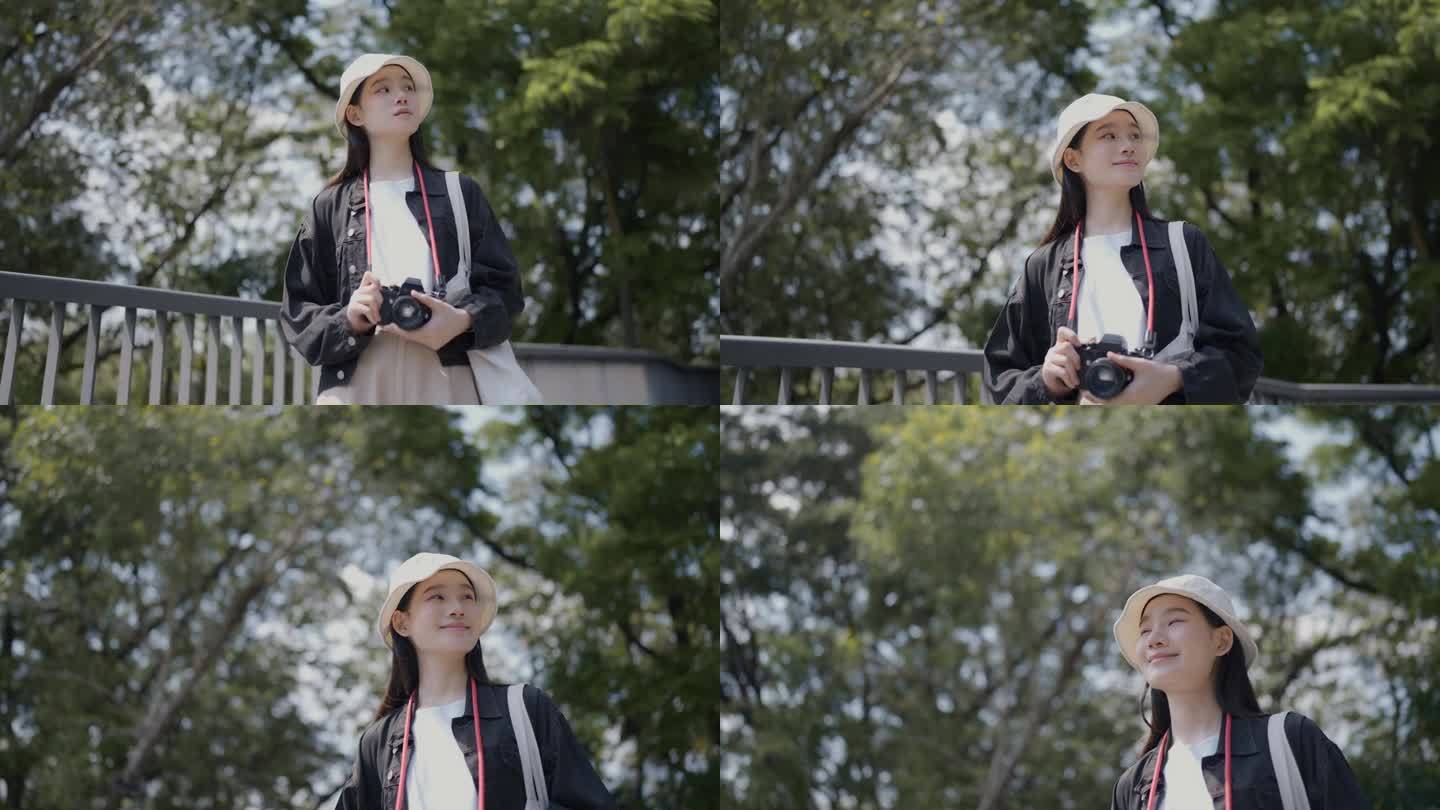 心情愉快的亚洲女游客在公园里拿着相机，带着一种清新的感觉环顾四周