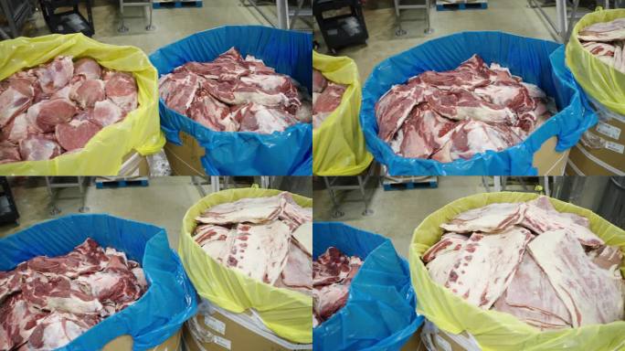 在一家工业肉类加工厂，生肉被切成桶状
