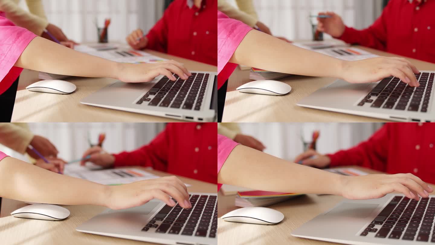 设计师团队使用笔记本电脑的慢动作手部特写。组合成的