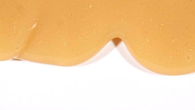 黄色化妆品凝胶流体与分子气泡流动在纯白色背景。液体乳霜凝胶。天然有机化妆品、药品微距拍摄。生产特写。