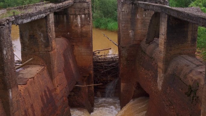 废弃的旧水坝，河水污浊。夹。河上的旧石坝，河水已生锈。夏天河上的石坝被毁。