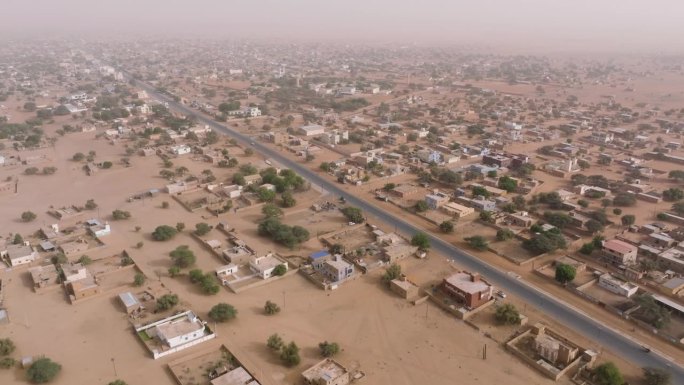 高空飞行。塞内加尔撒哈拉沙漠萨赫勒地区贫瘠景观中的典型城镇。干旱，气候变化，沙漠化