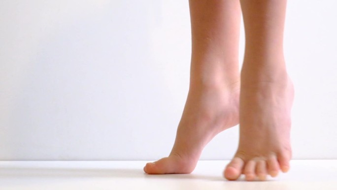 赤脚，脚尖腿，姿势，在芭蕾舞工作室练习，白色背景