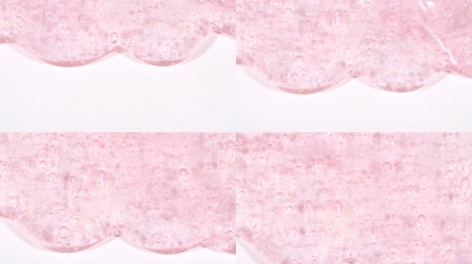 粉红色透明化妆品凝胶流体与分子气泡流动在白色的表面。微距镜头。液体乳霜凝胶透明化妆品样品纹理与泡沫。