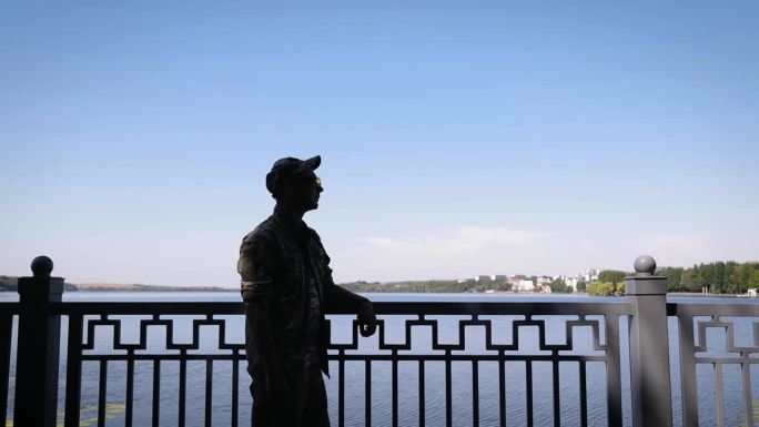 乌克兰武装部队。一个身穿军装的乌克兰士兵的剪影，背景是一个湖。这个人戴着战术护目镜