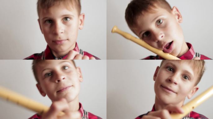 可爱的男孩脸肖像特写镜头鬼脸男孩拿着长笛在他的手中