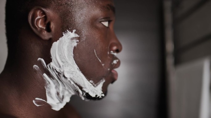 黑人青年用一次性刮胡刀刮胡