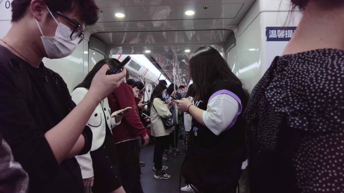坐地铁玩手机的人们