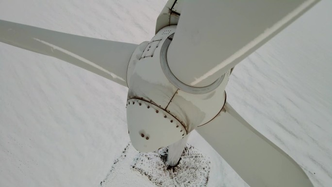 在农村用风力发电机进行无排放发电，靠近被寒冷的冬季积雪覆盖的农田