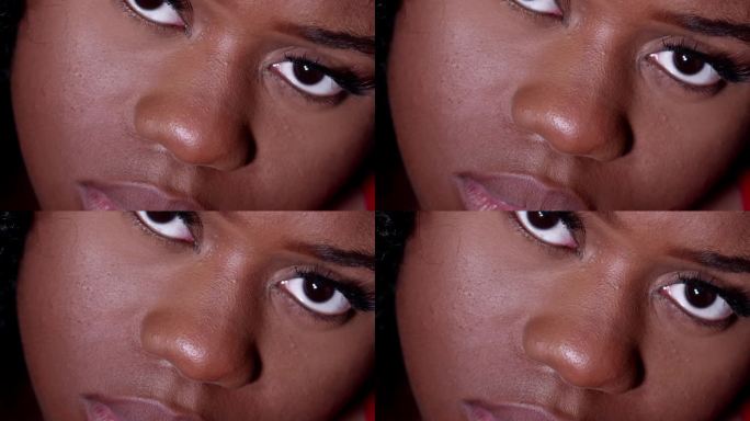 一位意志坚定的年轻非裔美国妇女睁开眼睛，看着镜头