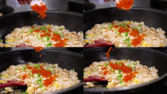 厨师将马萨古鱼籽洒在刚做的蟹炒饭上，近距离慢镜头4K