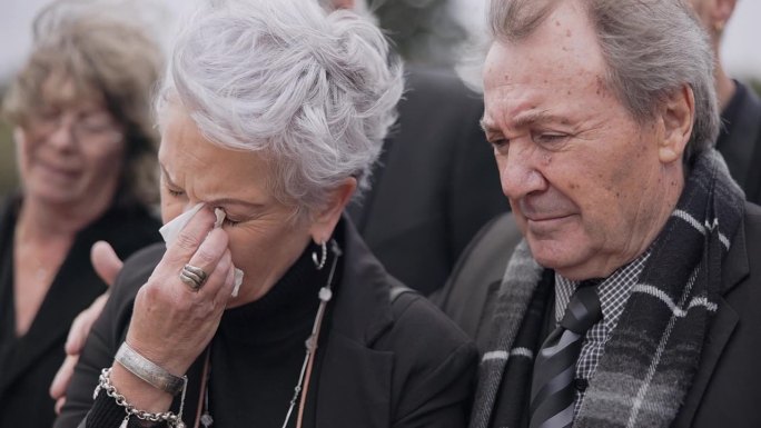 死亡、葬礼和老年夫妇在墓地的追悼会上一起哭泣，为失去亲人而痛苦或悲伤。用来流泪、支持或同情墓地里一对