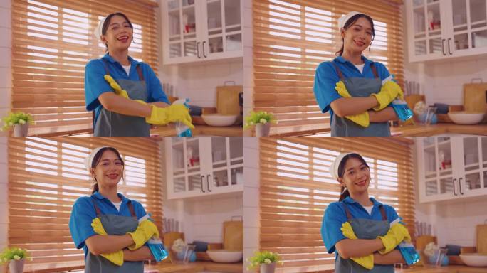 在厨房工作的亚洲清洁服务女工的肖像。美丽的女孩家庭主妇管家清洁工感到快乐和放松，享受家务或家务然后看
