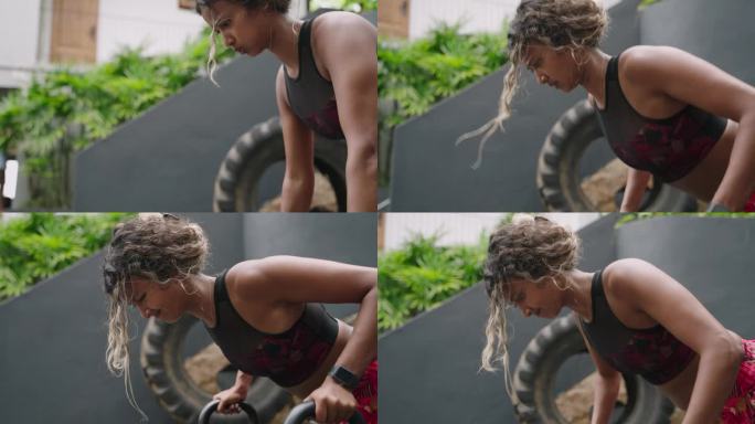 健美女子在户外健身房用壶铃做俯卧撑。混血女运动员专注于力量训练。肌肉健身教练锻炼，健身器材。运动，健