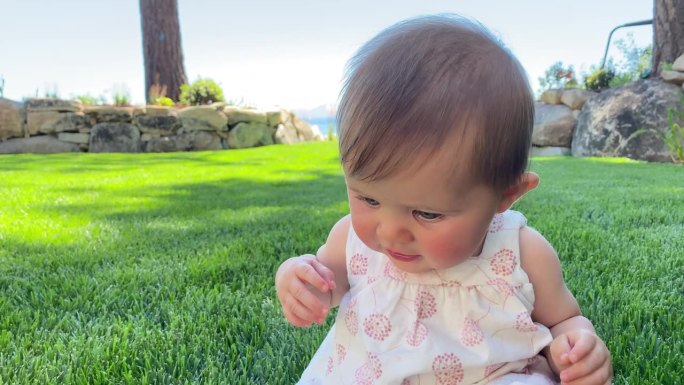 女婴第一次学习在草地上爬行