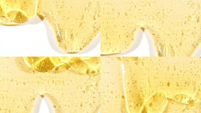 黄色透明化妆品凝胶液体与分子气泡流动在白色的表面。微距镜头。液体乳霜凝胶透明化妆品样品纹理与泡沫。