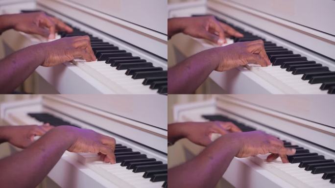 作曲家写新歌，在录音室弹钢琴，键盘上黑人的手特写