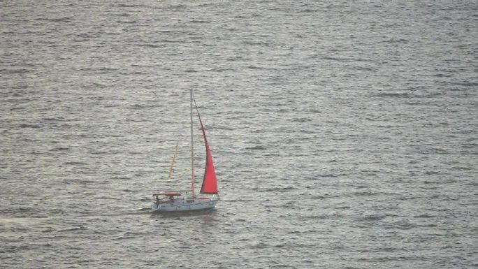 游艇在平静的日落海上。豪华游轮之旅。深蓝色水面上白色小船的侧视图。鸟瞰富裕的游艇在海上航行。夏季豪华