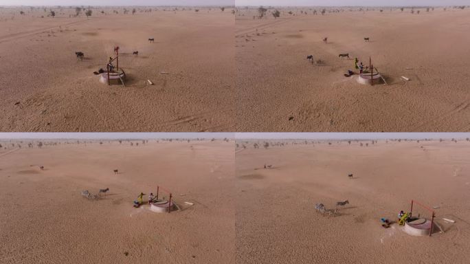 空中平移。在贫瘠的塞内加尔撒哈拉沙漠萨赫勒地区，三个黑人妇女在驴子的帮助下从一口深井里打水。干旱，气