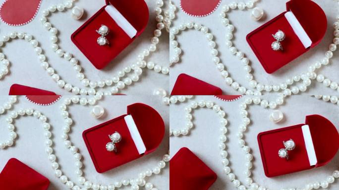 红盒子里的珍珠戒指。情人节浪漫的背景有珠宝，礼物有礼物，订婚戒指是旋转的