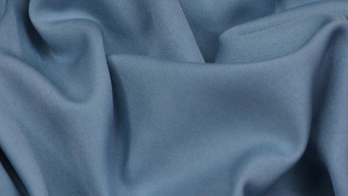 蓝色的织物。布。蓝色布料波浪背景纹理。
