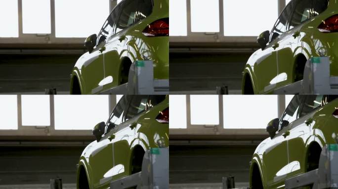 一辆石灰绿色汽车的侧视图停在明亮的车库里，光线透过窗户，部分视图