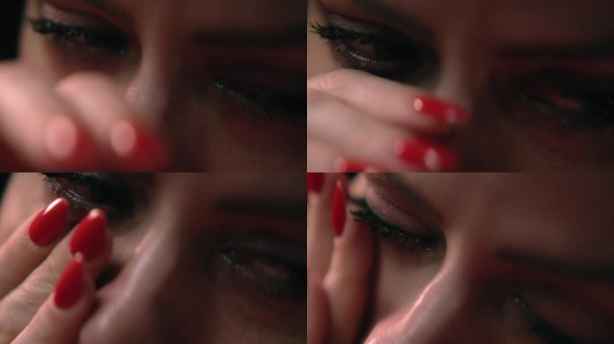 特写美女的眼睛在流泪。伤心欲绝的女人哭泣。擦去眼角的泪水