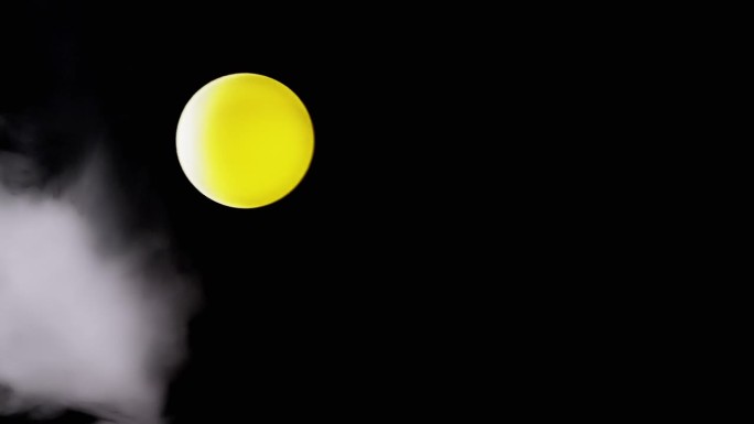 旋转的黄色球体与空白空间中气流中的烟雾的碰撞