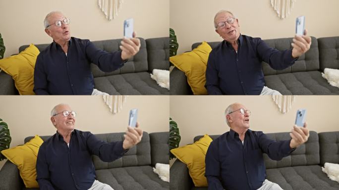 快乐的老人坐在家里的沙发上，用智能手机拍着表情丰富的自拍照，微笑照亮了整个房间