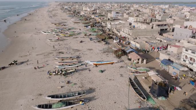 高空飞行。在塞内加尔的圣路易，五颜六色的皮划艇、令人震惊的塑料污染和垃圾躺在海洋的边缘
