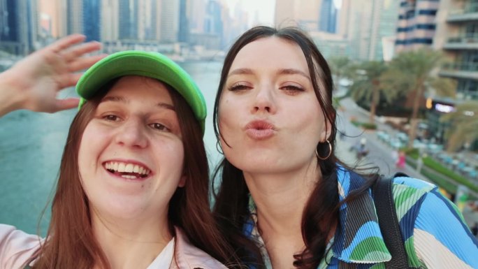 两个开心的女游客在迪拜码头自拍