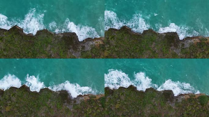 无人机顶向下上升，强大的海浪从大浪碰撞到加勒比海岛屿陡峭的悬崖