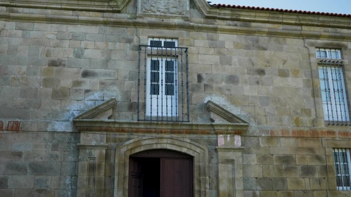 向上倾斜，可以看到敞开的修道院大门、笼窗和华丽的石雕入口