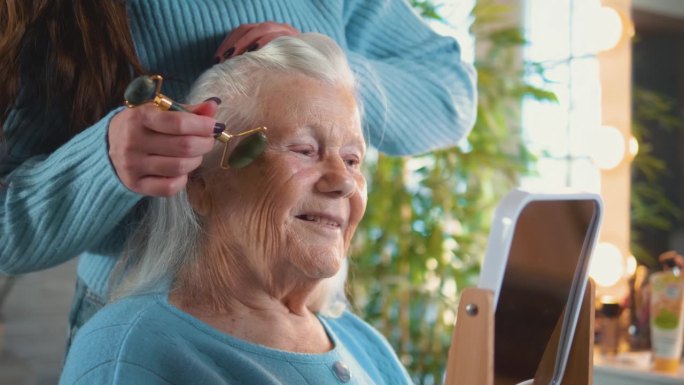 80年代，一位老妇人用玉石面部滚轮按摩脸部。老年妇女的关怀和美丽