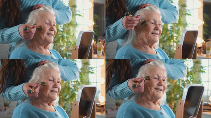 80年代，一位老妇人用玉石面部滚轮按摩脸部。老年妇女的关怀和美丽