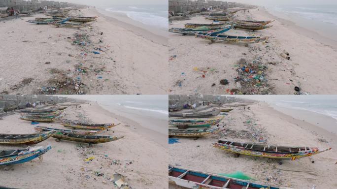空中特写。色彩斑斓的独木舟、令人震惊的塑料污染和垃圾就躺在海洋的边缘。塞内加尔圣路易