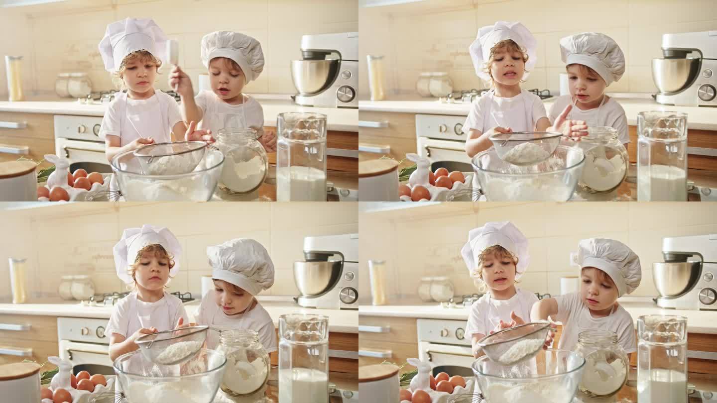 两个戴着厨师帽的幼儿在厨房里烹饪和分享食谱