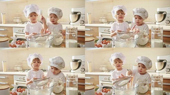 两个戴着厨师帽的幼儿在厨房里烹饪和分享食谱