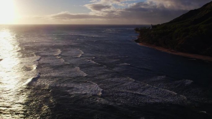 无人机拍摄的画面显示，随着太阳在水面上的反射，太平洋翻滚的海浪在檀香山附近的夏威夷瓦胡岛海岸荡起涟漪