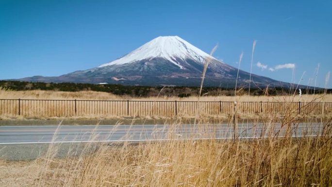 在蓝天的日子里，富士山映衬着群山和草地，是游客和旅行者的地标和目的地。大自然的美在平和中伴着缓慢的冬